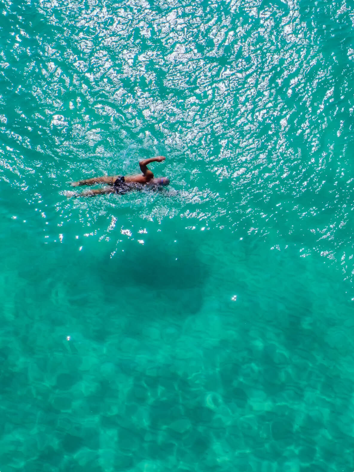 Person swimming in clear blue sea